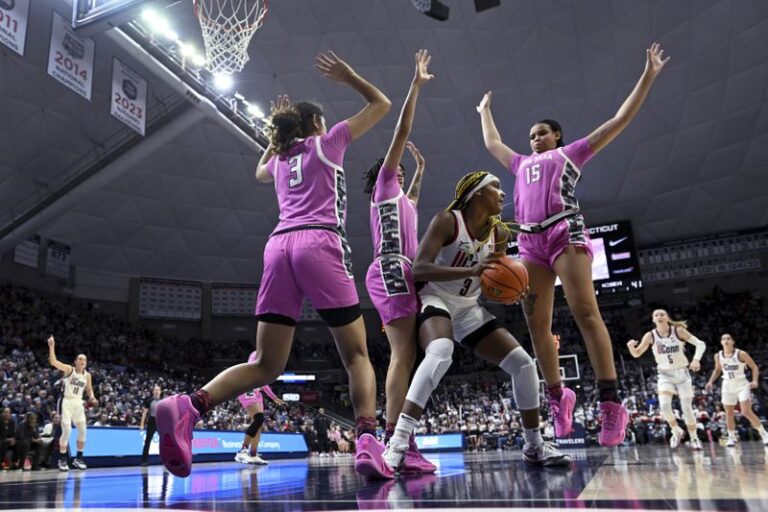 UConn forward Aaliyah Edwards (3) looks for a way out as Georgetown is triple-teamed during the second half of an NCAA college basketball game Friday, Feb. 16, 2024, in Storrs, Connecticut.  (Cloe Poisson/Hartford Courant via AP)