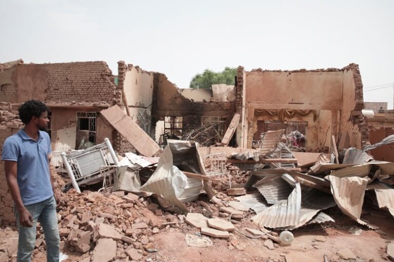 A man looks at a house damaged by recent fighting in Khartoum, Sudan.