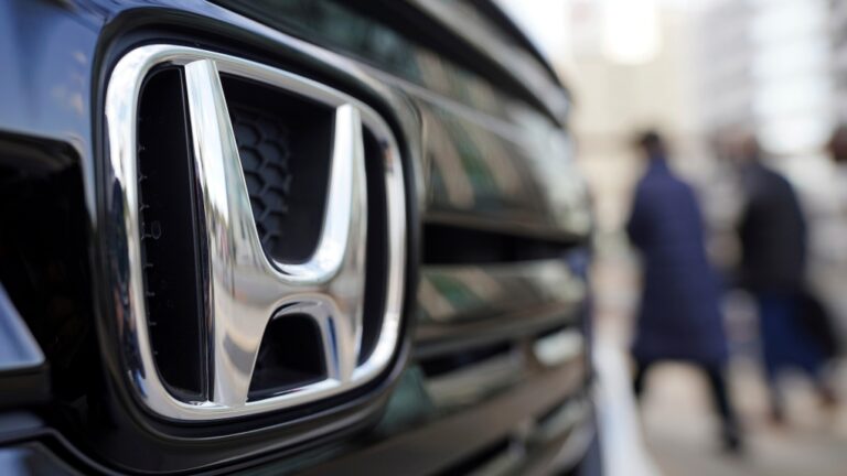 FILE - People walk near the logo of Honda Motor Company at a showroom Tuesday, Feb. 8, 2022, in Tokyo.  (AP Photo/Eugene Hoshiko, File)