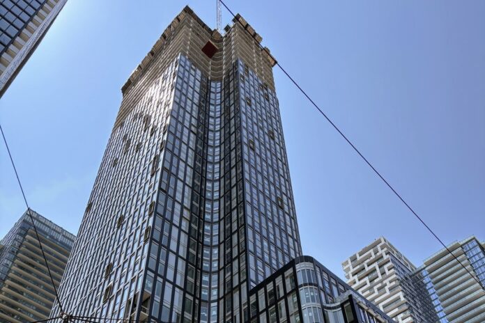 Alias Nears Final Height as Brickwork and Gold Accents Define the Facade