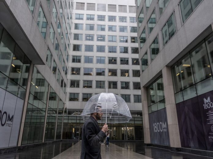 A man passes a building with office space for rent in Washington, DC,