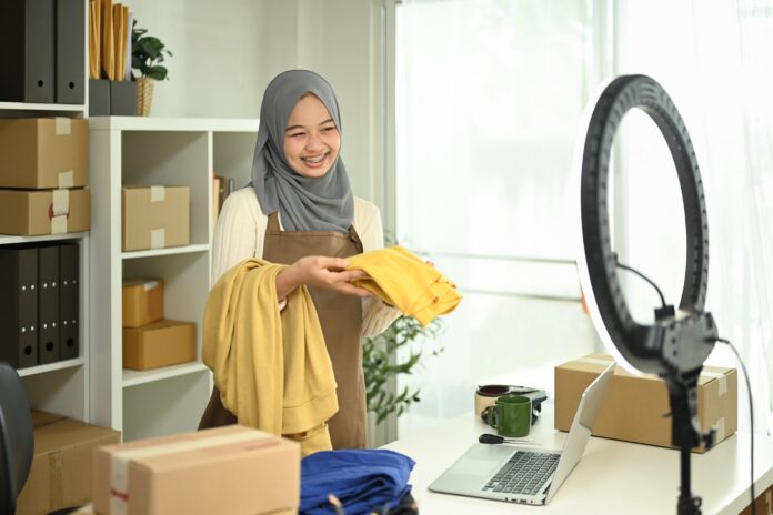 Young Muslim woman with hijab working live streaming to sell products.