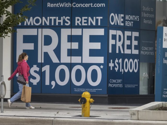 A person walks past an advertisement for Concert Properties The Kip District 