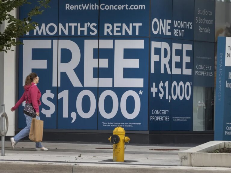 A person walks past an advertisement for Concert Properties The Kip District 