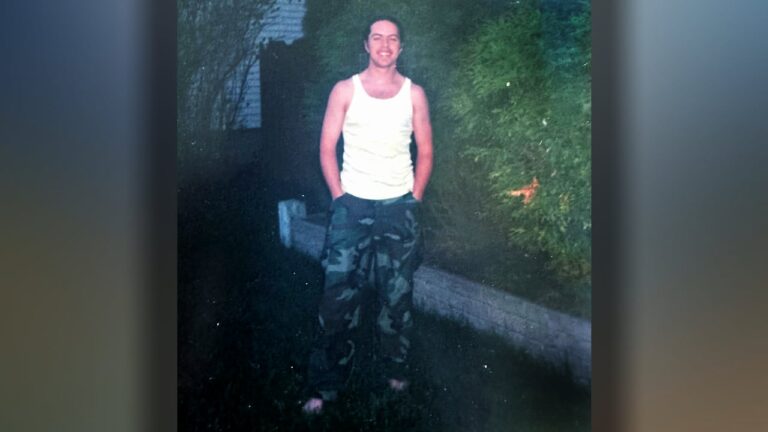 Mann mit Tanktop und Tarnhose.